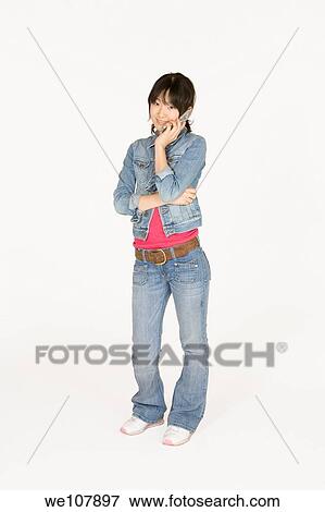 Portrait of a beautiful Asian teenager talking on a cell phone on a white background View Large Photo Image Stock Photo - Portrait of a beautiful Asian teenager talking on a cell phone on a white background. Fotosearch