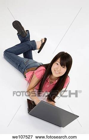 Portrait of Asian teenager working with a laptop conputer on a white background View Large Photo Image Stock Photo - Portrait of Asian teenager working with a laptop conputer on a white background. Fotosearch