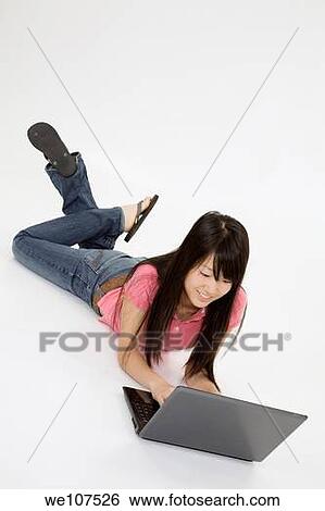 Portrait of Asian teenager working with a laptop conputer on a white background View Large Photo Image Stock Photograph - Portrait of Asian teenager working with a laptop conputer on a white background. Fotosearch