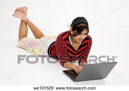 Portrait of Indian teenager working with a laptop conputer on a white background View Large Photo Image Stock Photo - Portrait of Indian teenager working with a laptop conputer on a white background. Fotosearch