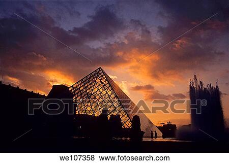 Stock Photo - Silhouetted glass pyramid and buildings of the Musée du Louvre, Paris, France. Fotosearch