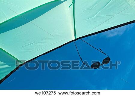 Sunglasses suspended from a sunshade against a blue sky View Large Photo Image Stock Photography - Sunglasses suspended from a sunshade against a blue sky. Fotosearch