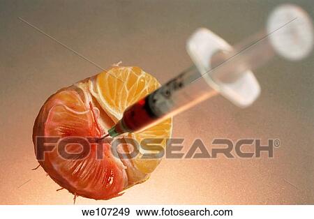 Syringe needle jabbed into a mandarin showing the possibility of genetically modified food View Large Photo Image Stock Photo - Syringe needle jabbed into a mandarin showing the possibility of genetically modified food. Fotosearch