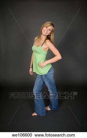 Stock Image - Teenage girl posing on gray background with some attitude. Fotosearch