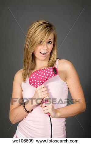Teenage girl posing on gray background with some attitude and a blowdryer View Large Photo Image Stock Photo - Teenage girl posing on gray background with some attitude and a blowdryer. Fotosearch