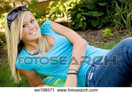 Stock Image - Teenage girl relaxing in the grass. Fotosearch