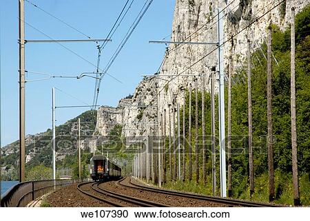 Train travelling between the Rhone River and Defile Cliffs in Drome, France View Large Photo Image Stock Image - Train travelling between the Rhone River and Defile Cliffs in Drome, France. Fotosearch