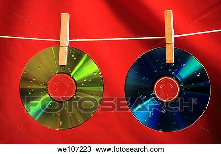 Stock Image - Two wet compact discs drying on a washing line. Fotosearch