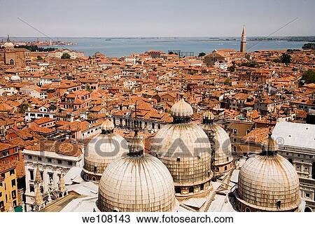Stock Image - Venice rooftops with the domes of Basilica San Marco in the foreground Venice Italy. Fotosearch