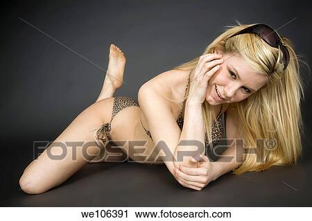 Stock Image - Woman posing in a swimsuit with some attitude on a gray background. Fotosearch