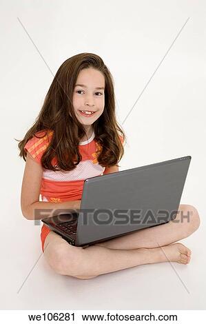 Young girl playing on a laptop computer on a white background View Large Photo Image Stock Image - Young girl playing on a laptop computer on a white background. Fotosearch