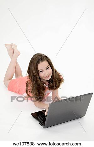 Young girl playing on a laptop computer on a white background View Large Photo Image Stock Photo - Young girl playing on a laptop computer on a white background. Fotosearch