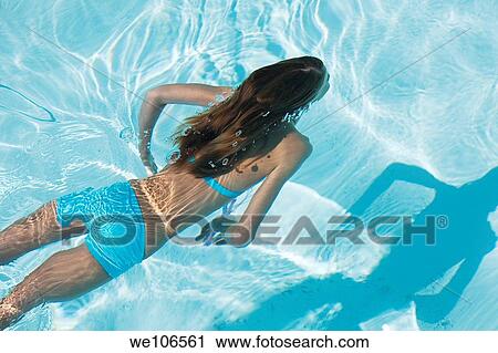 Young girl swimming under water View Large Photo Image Stock Image - Young girl swimming under water. Fotosearch