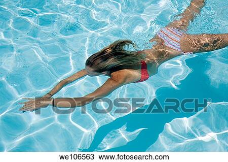 Young girl swimming under water View Large Photo Image Stock Image - Young girl swimming under water. Fotosearch