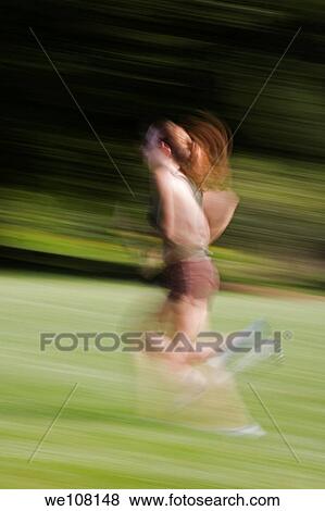 Young woman in early 20s jogging in park View Large Photo Image Stock Photo - Young woman in early 20s jogging in park. Fotosearch