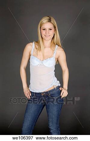 Stock Photo - Young woman posing on gray background in jeans and aqua top. Fotosearch