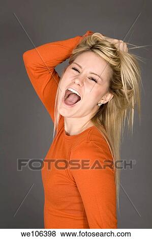 Young woman posing on gray background shouting at the camera View Large Photo Image Stock Photo - Young woman posing on gray background shouting at the camera. Fotosearch