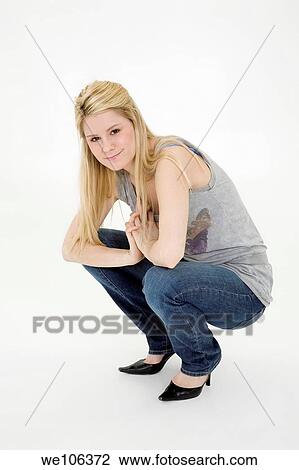 Stock Image - Young woman posing on white background with some attitude. Fotosearch