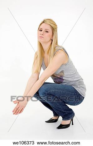 Stock Image - Young woman posing on white background with some attitude. Fotosearch