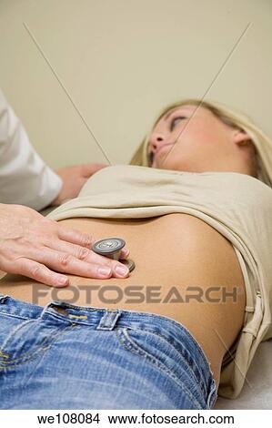 Picture - A doctor examining a teenage female patient. Fotosearch