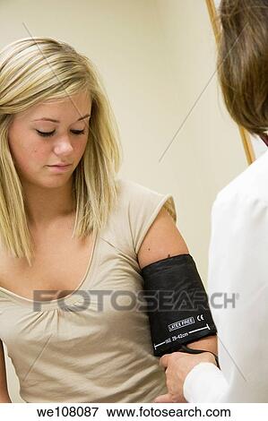 A doctor examining a teenage female patient Having her blood pressure checked View Large Photo Image Stock Photo - A doctor examining a teenage female patient Having her blood pressure checked. Fotosearch