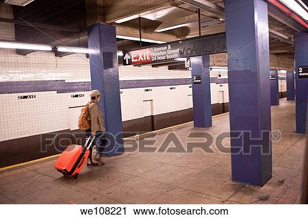 A lone traveler pulls an orange suitcase on an empty subway platform in New York City. View Large Photo Image Stock Image - A lone traveler pulls an orange suitcase on an empty subway platform in New York City.. Fotosearch