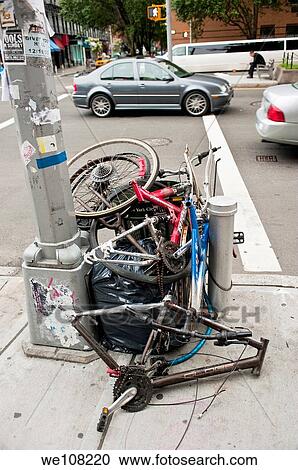 A pile of stripped down bicycles and a garbage bag next to a light pole on a street corner in New York City. View Large Photo Image Stock Image - A pile of stripped down bicycles and a garbage bag next to a light pole on a street corner in New York City.. Fotosearch