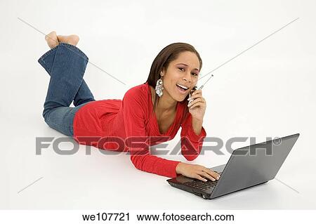 African American teen working on laptop computer and talking ona cell phone View Large Photo Image Stock Image - African American teen working on laptop computer and talking ona cell phone. Fotosearch