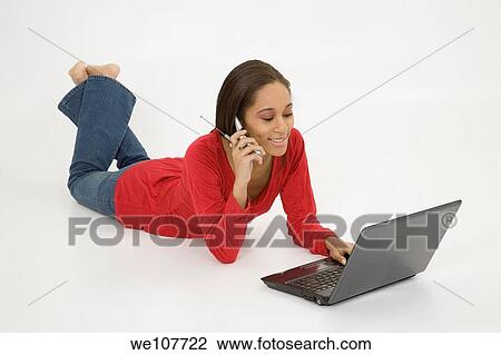 African American teen working on laptop computer and talking ona cell phone View Large Photo Image Stock Image - African American teen working on laptop computer and talking ona cell phone. Fotosearch
