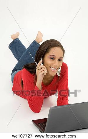African American teen working on laptop computer and talking ona cell phone View Large Photo Image Stock Photo - African American teen working on laptop computer and talking ona cell phone. Fotosearch