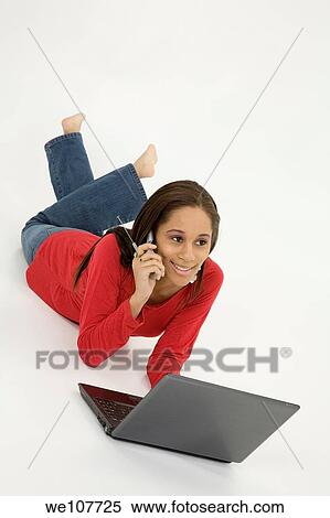 African American teen working on laptop computer and talking ona cell phone View Large Photo Image Stock Photography - African American teen working on laptop computer and talking ona cell phone. Fotosearch