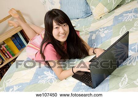 Asian American teen working on laptop computer View Large Photo Image Stock Image - Asian American teen working on laptop computer. Fotosearch