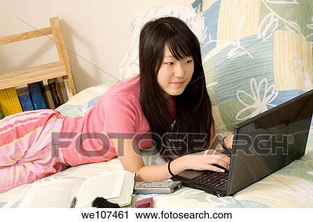 Asian American teen working on laptop computer View Large Photo Image Stock Image - Asian American teen working on laptop computer. Fotosearch