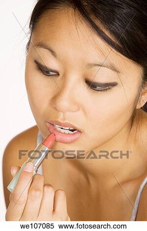 Asian woman applying lip stick View Large Photo Image Stock Photography - Asian woman applying lip stick. Fotosearch