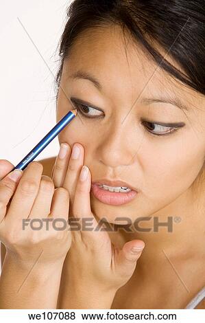 Asian woman applying make up View Large Photo Image Stock Photo - Asian woman applying make up. Fotosearch