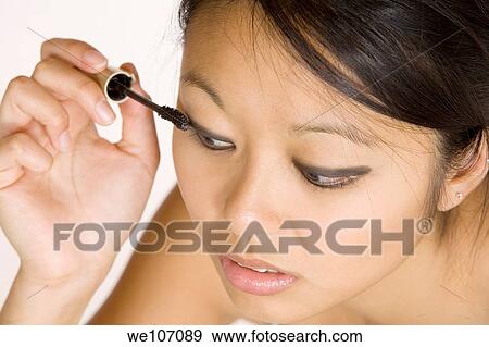 Asian woman applying mascara View Large Photo Image Stock Photo - Asian woman applying mascara. Fotosearch