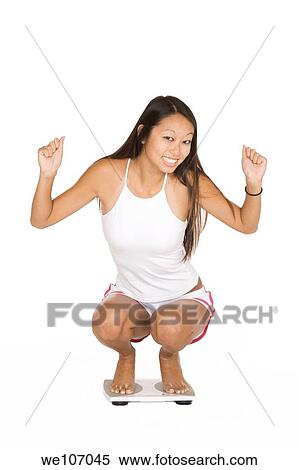 Asian woman in her early 20's weighting herself View Large Photo Image Stock Photography - Asian woman in her early 20's weighting herself. Fotosearch