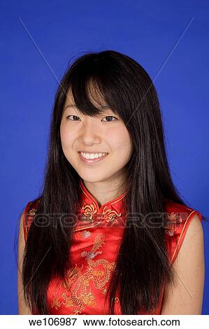 Beautiful Asian teenager in traditional dress on blue background View Large Photo Image Stock Photo - Beautiful Asian teenager in traditional dress on blue background. Fotosearch