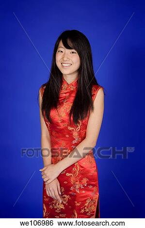 Beautiful Asian teenager in traditional dress on blue background View Large Photo Image Stock Photograph - Beautiful Asian teenager in traditional dress on blue background. Fotosearch