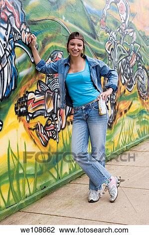 Beautiful Brazilian girl spray painting a mural on the side of a building View Large Photo Image Stock Image - Beautiful Brazilian girl spray painting a mural on the side of a building. Fotosearch