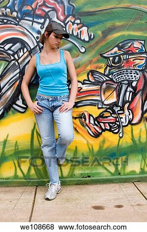 Beautiful Brazilian girl spray painting a mural on the side of a building View Large Photo Image Stock Photo - Beautiful Brazilian girl spray painting a mural on the side of a building. Fotosearch