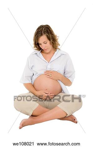 Stock Image - Caucasian woman who is 9 months pregnant on white background. Fotosearch