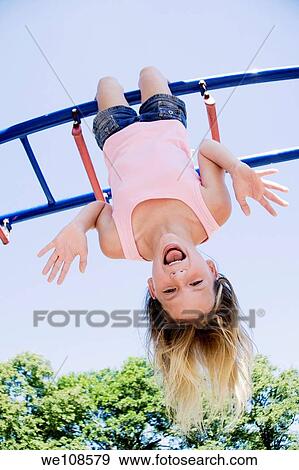 Eleven year old girl playing on gym bars in park View Large Photo Image Stock Photo - Eleven year old girl playing on gym bars in park. Fotosearch