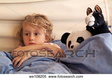 Little girl watching TV in bed, surrounded by her favourite stuffed animals View Large Photo Image Stock Photography - Little girl watching TV in bed, surrounded by her favourite stuffed animals. Fotosearch