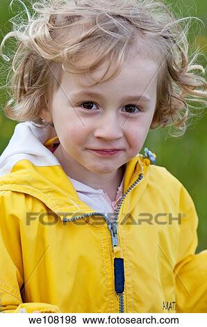 Stock Photo - Little girl wearing a yellow raincoat, Provence, France. Fotosearch