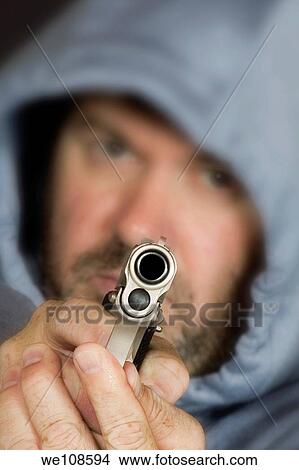 Man hold gun in a threatening pose View Large Photo Image Picture - Man hold gun in a threatening pose. Fotosearch