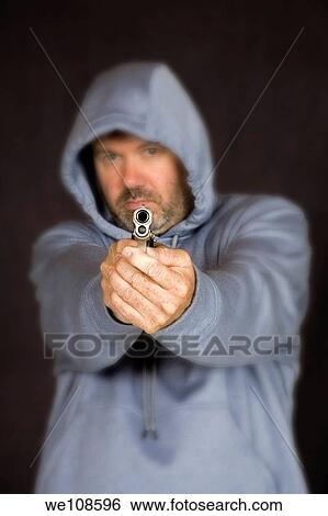 Stock Photograph - Man holding a gun in a threatening pose. Fotosearch