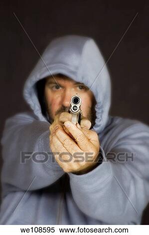 Man holding gun in a threatening pose View Large Photo Image Stock Photography - Man holding gun in a threatening pose. Fotosearch