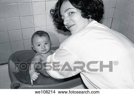Picture - Mother bathing her baby boy, France. Fotosearch