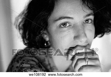 Stock Image - Portrait of a woman looking thoughtfully at the camera, France. Fotosearch